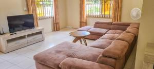 a living room with a couch and a flat screen tv at Kapowlito Real Estate Casa #1 Mon Plaisirweg in Paramaribo