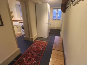 a hallway of a kitchen with a refrigerator and a rug at Fairy Glen in Ambleside +47 photos