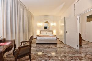 een slaapkamer met een bed, een tafel en een bureau bij Soderini Splendor: First Floor Palazzo Charm at Castello Square in Venetië