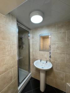 a bathroom with a sink and a shower at Comfortable Modern Home, Self Catering Flat, Newly refurbished, town centre, free parking in Cheltenham
