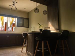a kitchen with a bar with black bar stools at House of Zen in Santa Cruz