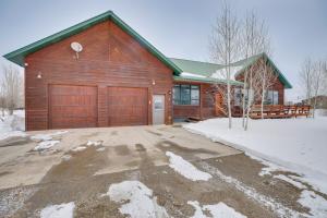 a wooden house with a garage in the snow at Spacious Gunnison Home Ski, Hike, Bike and Fish! in Gunnison