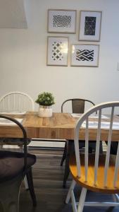 uma mesa de madeira com cadeiras e um vaso de plantas sobre ela em Cozy 2BR in VieuxLongueuil +parking 14min Downtown em Longueuil