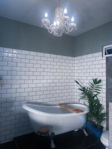 a bathroom with a large white tub and a chandelier at House of Zen in Santa Cruz