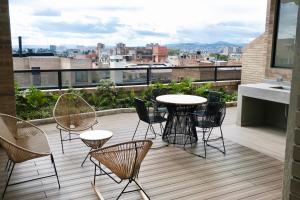 a patio with chairs and a table on a balcony at Kubik apartments in Exclusive Virrey in Bogotá