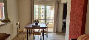 a dining room with a table and chairs and a window at Residencial Privé das Thermas I in Caldas Novas