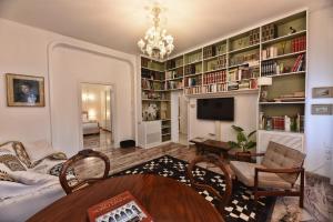 een woonkamer met een bank, een tv en boekenplanken bij Soderini Splendor: First Floor Palazzo Charm at Castello Square in Venetië