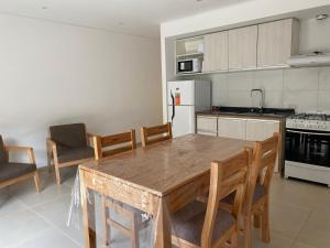 a kitchen with a wooden table and chairs in it at Ubatuba Lofts Mar Azul - depto 2 hab in Mar Azul