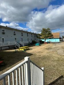 a white building with a white fence and a playground at Flamingo Villa @ The Reef in Chincoteague +2 photos