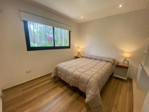 a bedroom with a bed and a window at Ubatuba Lofts Mar Azul - depto 2 hab in Mar Azul