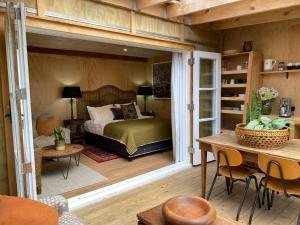 - une chambre avec un lit et une table dans l'établissement The Bay Cottage - Located Directly Across the Road from 2 Swimming Beaches, sur l’île de la Grande Barrière