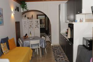 a living room with a table and a kitchen at A viuzza in Cefalù