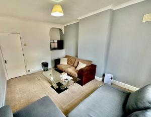 a living room with a couch and a glass table at Stay in Whitechapel apartment in London