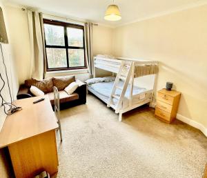 a small room with a bunk bed and a couch at Stay in Whitechapel apartment in London