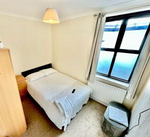 a small bedroom with a bed and a window at Stay in Whitechapel apartment in London