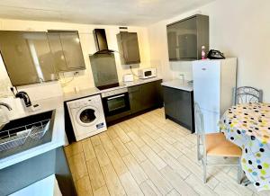 eine Küche mit einem weißen Kühlschrank und einem Tisch mit einem Esszimmer in der Unterkunft Stay in Whitechapel apartment in London