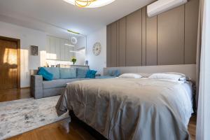 a bedroom with a large bed and a couch at 4 Ljubavi in Palić +25 photos