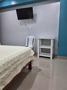 1 dormitorio con 1 cama, escritorio y TV en Hospedaje Huamani & Mi Casa, en Pisco