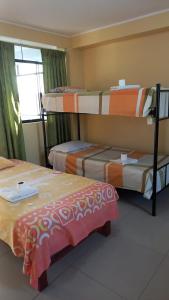 皮斯科的住宿－Hospedaje Huamani & Mi Casa，客房设有三张双层床和一扇窗户。