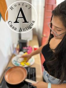 a woman is preparing food in a kitchen at Apartamento Casa Antigua in Santa Ana