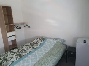 una camera con un letto con una coperta verde e bianca di Gîte Bamas a Saint-Dizier