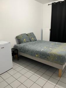 a bed in a room with a black curtain at Gîte Bamas in Saint-Dizier