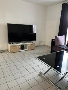 un soggiorno con TV a schermo piatto e pavimento piastrellato di Gîte Bamas a Saint-Dizier