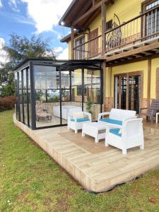 a house with a deck with white furniture on it at Finca hotel la fortuna in San Pedro