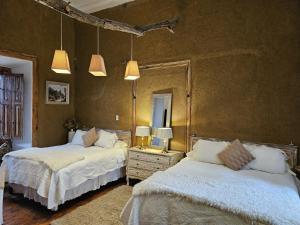 a bedroom with two beds and a mirror at Hotel Boutique Terra Diaguita & Spa in La Serena