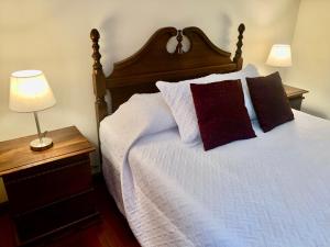 una camera da letto con un grande letto con due cuscini di Apartamento Mayan Plaza a Rovine di Copán