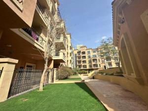 a grassy yard next to a building with a tree at Diomond view 4 in Dubai