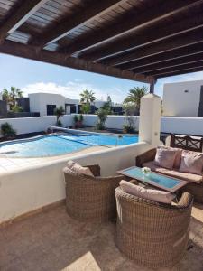 een patio met stoelen en een zwembad bij Casa Sophia in Playa Blanca