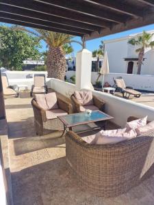 a patio with wicker furniture and a table and chairs at Casa Sophia in Playa Blanca
