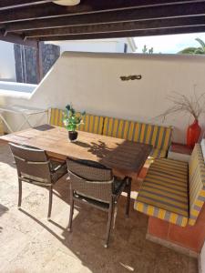 uma mesa de madeira e duas cadeiras e uma mesa e um banco em Casa Sophia em Playa Blanca