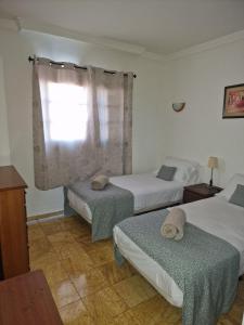 sypialnia z dwoma łóżkami i oknem w obiekcie Casa Sophia w mieście Playa Blanca