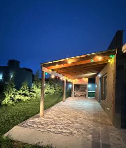 a pergola with lights on the side of a building at Cabaña en Villa del Deportista Villa Shalom in Necochea +4 photos