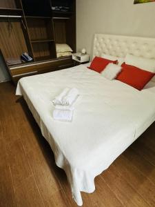 1 cama blanca grande con toallas y almohadas. en Cabaña en Villa del Deportista Villa Shalom en Necochea