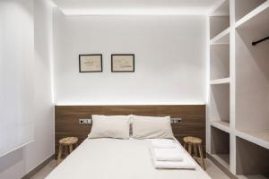 1 dormitorio con 1 cama blanca y 2 taburetes en Luxury flats PCL by Clabao, en Logroño