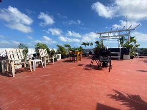 a group of chairs and tables on a roof at LUX Studio ROOM LAS PALMAS PUERTO MORELOS in Puerto Morelos