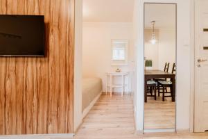 un soggiorno con TV a schermo piatto su una parete in legno di Villa Baltica Gdańsk a Danzica