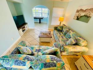 a living room with a couch and a tv at Beach Condo with Game Room Steps To Beach in Clearwater Beach
