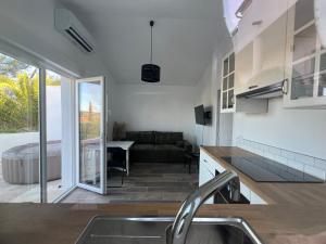 eine Küche mit einem Waschbecken und ein Wohnzimmer in der Unterkunft maison t2 avec jaccuzi wifi parking in Saint-Cyr-sur-Mer