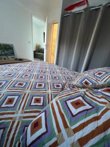 a bed with a colorful quilt on top of it at maison t2 avec jaccuzi wifi parking in Saint-Cyr-sur-Mer