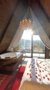 um quarto com uma cama com um lustre e uma banheira em Chalés Capivari Diamante em Campos de Jordão