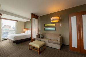 a hotel room with a bed and a couch at Hotel Dann Carlton Marinn Place Panama Financial District in Panama City