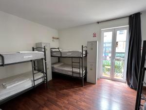 サンタンデールにあるAlojamientos Cantíberの二段ベッド3組とドアが備わる客室です。