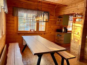 a wooden table in a kitchen in a cabin at Log cabin in 15 min from Rovaniemi center- 3bdr-Sauna-Fireplace in Rovaniemi