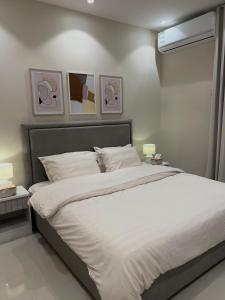 ein Bett in einem Schlafzimmer mit zwei Bildern an der Wand in der Unterkunft ALMALQA HAVEN - الملقا - الرياض in Riad