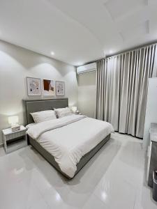 ein weißes Schlafzimmer mit einem großen Bett und einem Fenster in der Unterkunft ALMALQA HAVEN - الملقا - الرياض in Riad