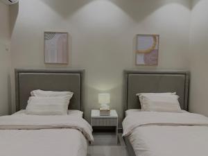 2 Betten nebeneinander in einem Zimmer in der Unterkunft ALMALQA HAVEN - الملقا - الرياض in Riad
